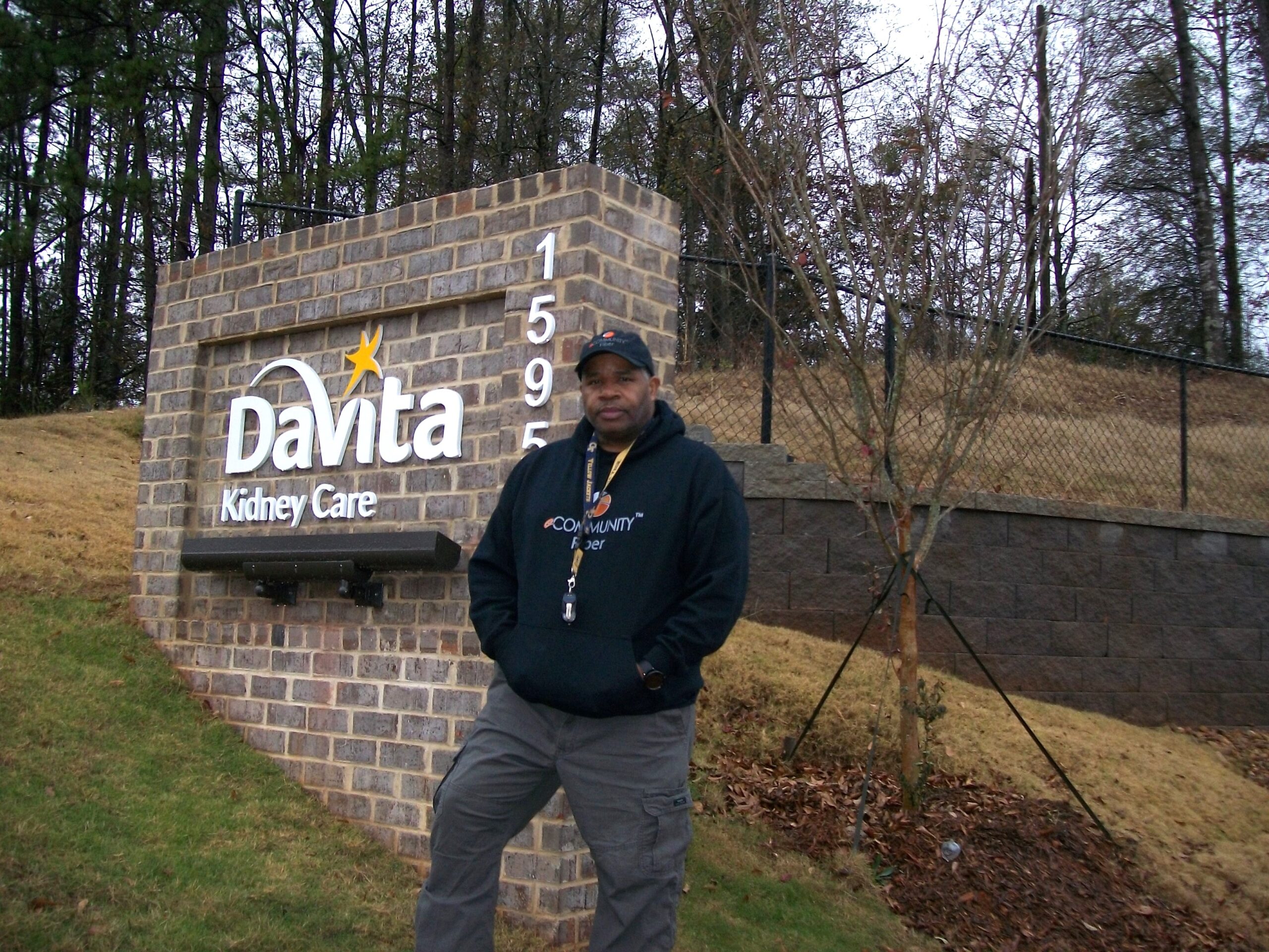 Man stands outside sign for Davita