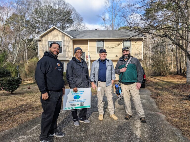 Antwon Alsobrook, Founder & CEO of A2D Inc. (left) and Julian Phelps, Operations Manager of A2D Inc. (center left) pose with installation technicians from Alliance Global Solutions (AGS) outside of a recent installation in Riverdale, GA.